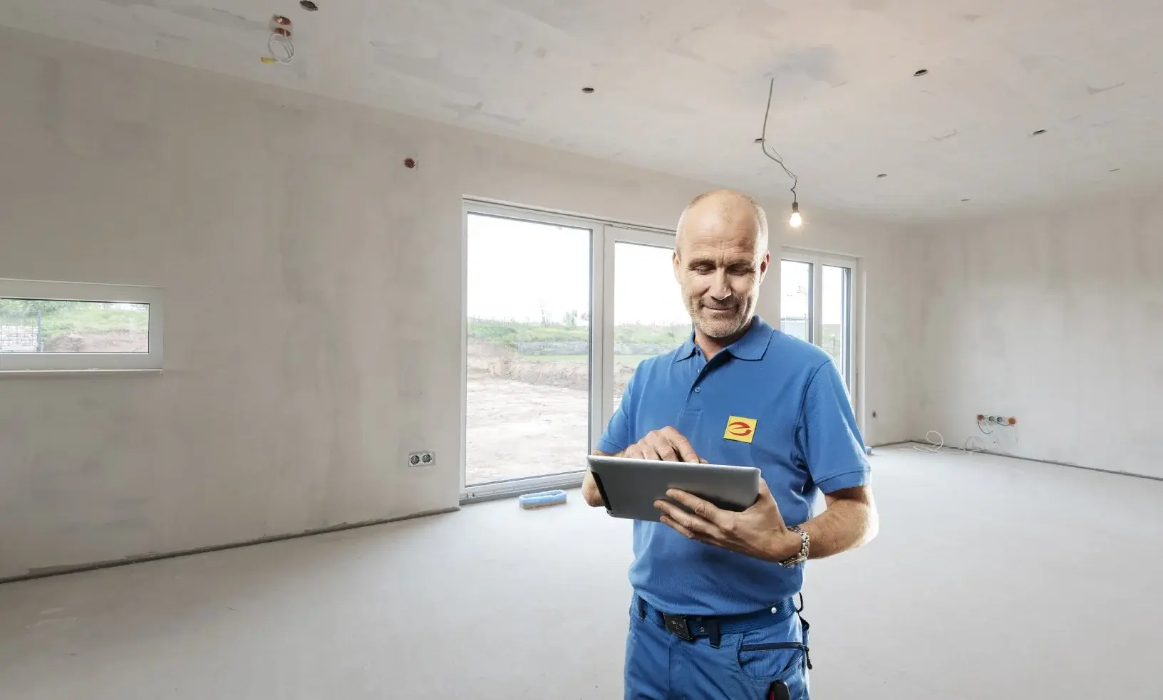 Man op tablet in een kale woning