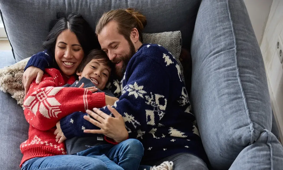 Papa mama en kind knuffelen op de bank