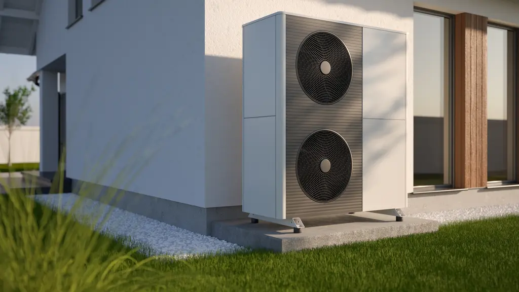 Een witte lucht-warmtepomp met twee grote ventilatoren is geïnstalleerd buiten een modern huis op een betonnen plaat, omgeven door groen gras en landschapsarchitectuur.